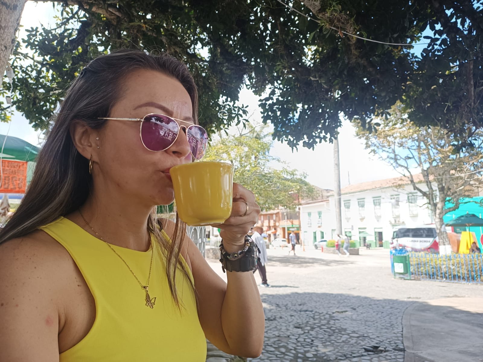 Diana Laverde with a cup of coffee in a town square in Antioquia, Colombia