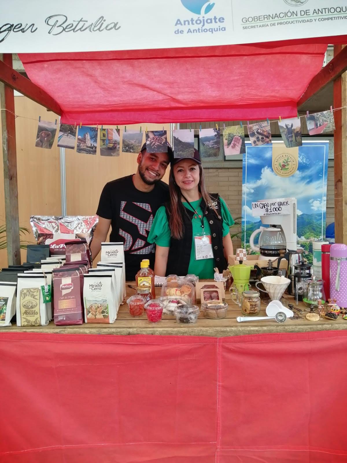Diego and Diana behind a coffee stand at a producer fair in Antioquia, Colombia
